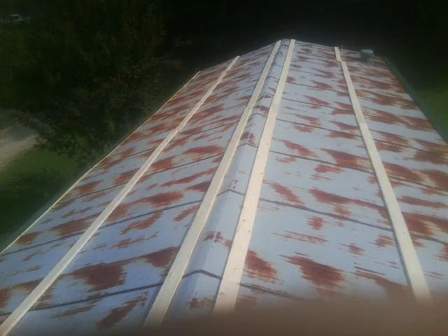 Rusted metal roof panels with new wood purlins before replacement — Storm Damage Roof Repair in Huntsville by Roofing Brothers