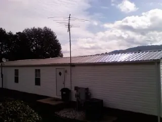 New metal roof on a single wide mobile home with a TV antenna in Huntsville