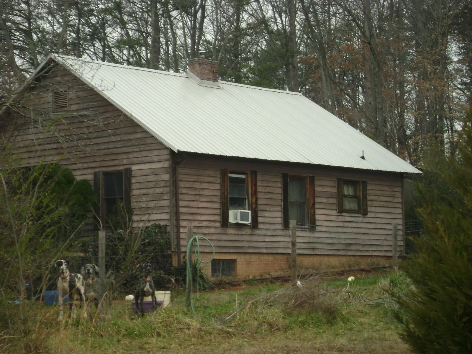 White metal roof on an old wood sided farmhouse, from a Metal Roof Installation job in Huntsville